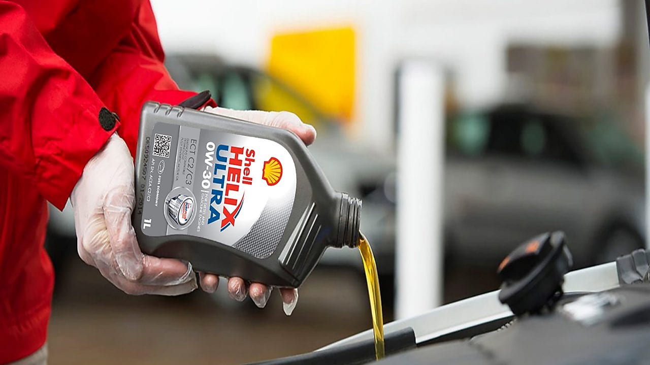 Shell Helix being poured into a car engine