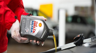 Shell Helix being poured into a car engine