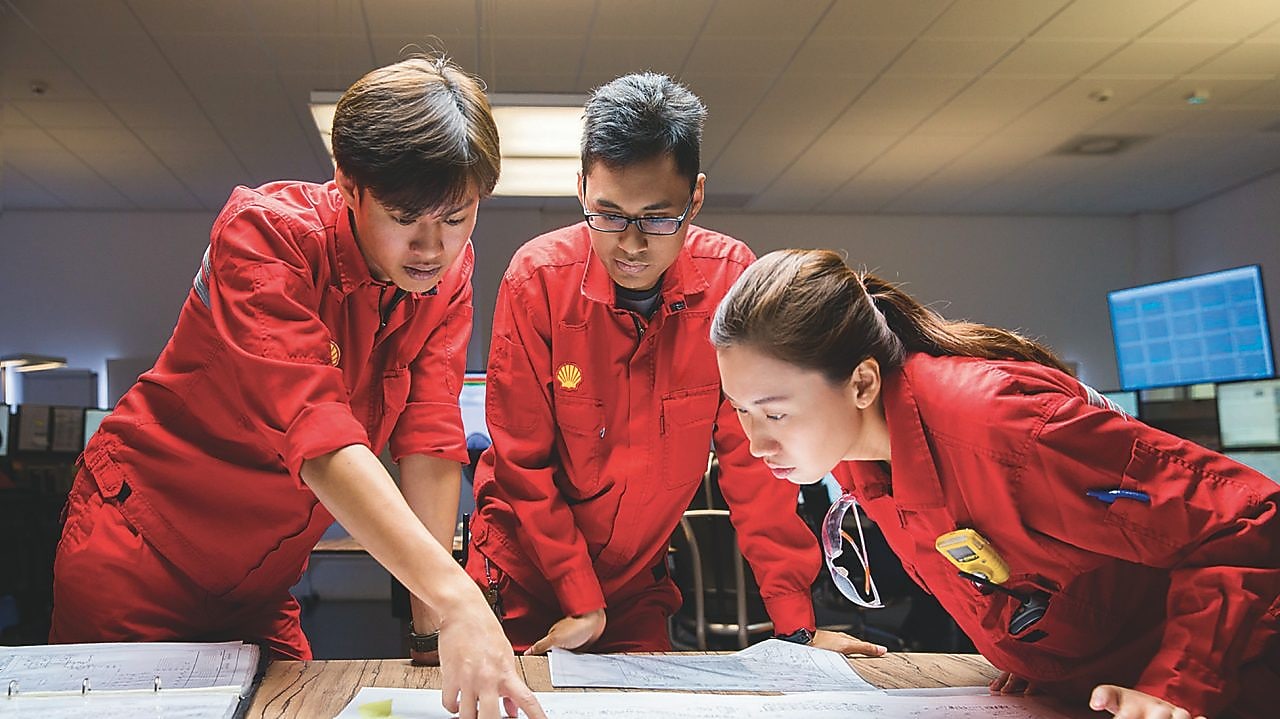 ثلاثة موظفين يراجعون الخطط