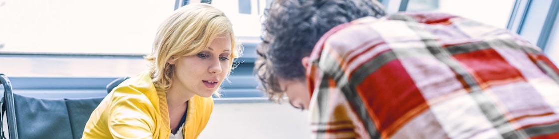 سيدة على كرسي متحرك تتحدث إلى رجل