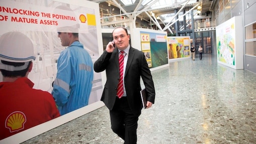 أندي نين يمشي ويتحدث على الهاتف في مكتب شل