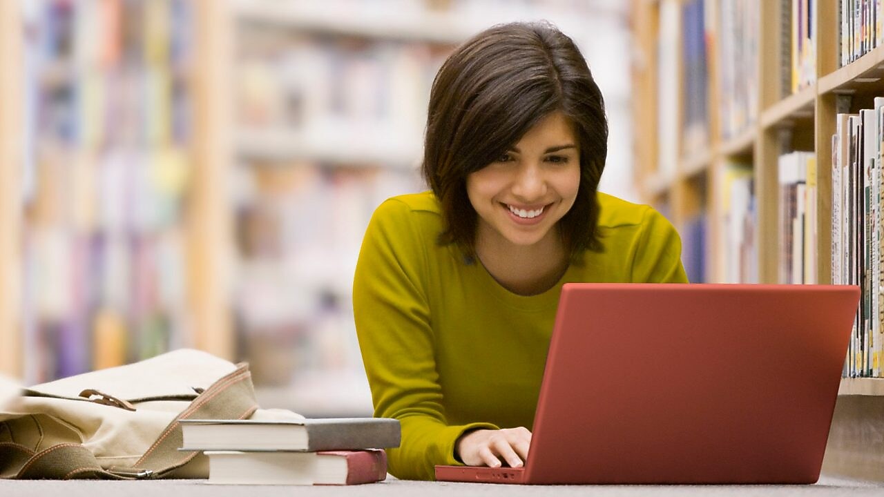 سيدة تنظر إلى شاشة جهاز حاسوبها المحمول