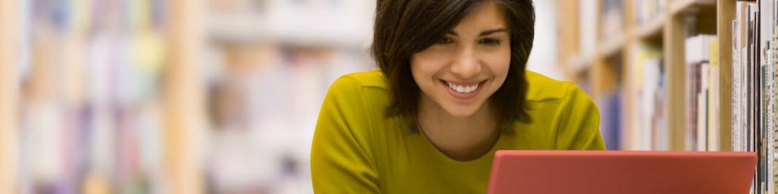 سيدة تنظر إلى شاشة جهاز حاسوبها المحمول 