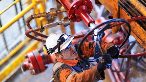 رجل يعمل على منصة مرتديا زي السلامة الكامل