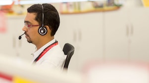 رجل يحتسي قهوة ينظر إلى هاتفه الذكي