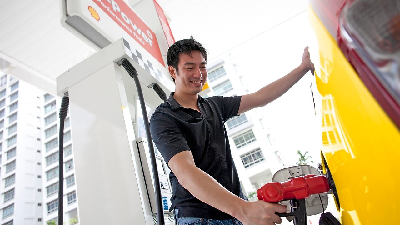 رجل يعيد تعبئة سيارته في محطة وقود
