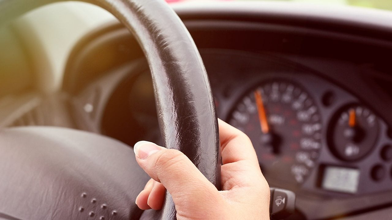 يد تمسك بعجلة قيادة