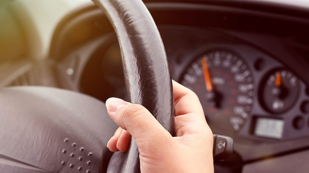 يد تمسك بعجلة قيادة