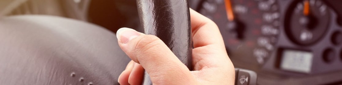 يد تمسك بعجلة قيادة