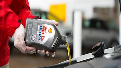 Shell Helix being poured into a car engine