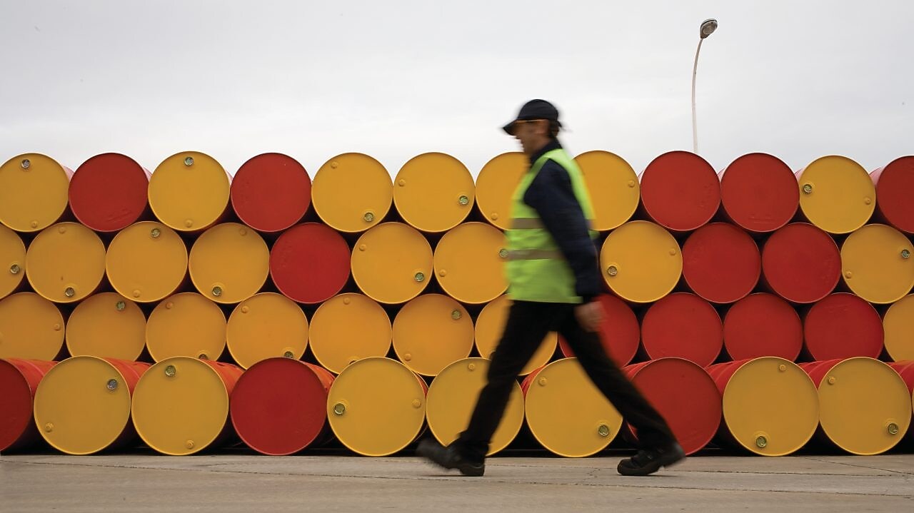 man walking barrels lubricants