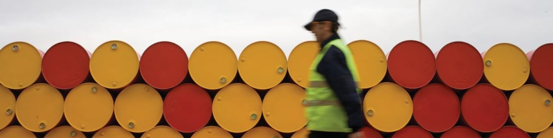 man walking barrels lubricants