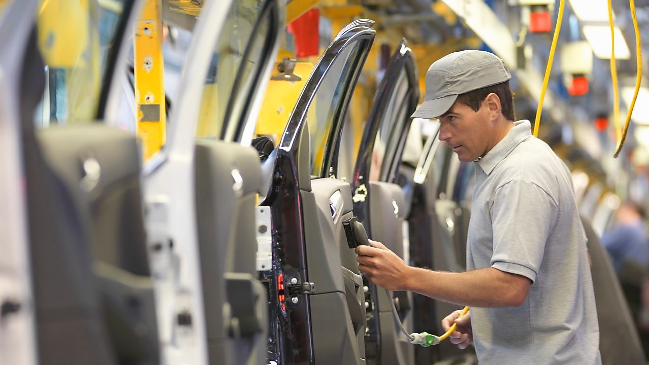 man holding wire looking at machine