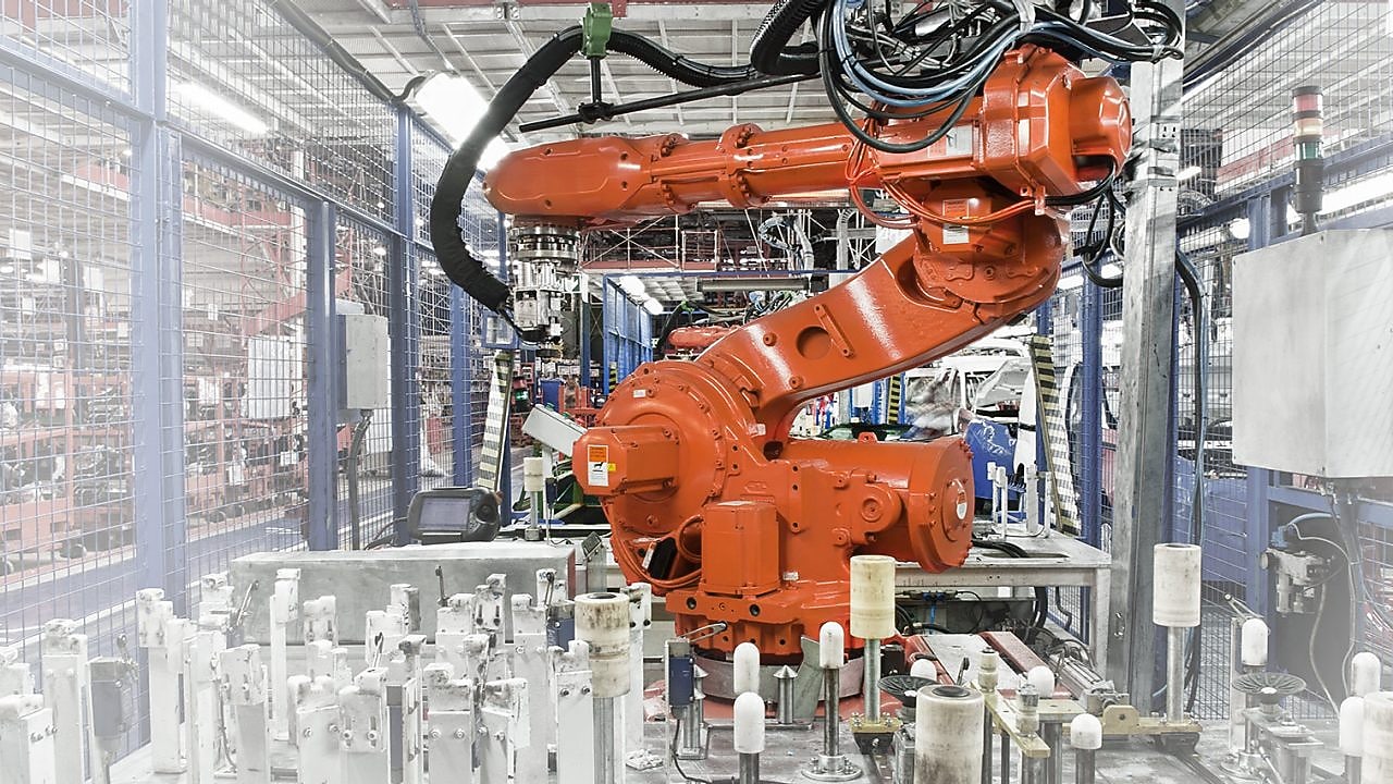 a red robotic arm in a factory
