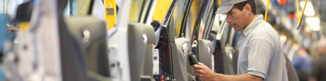 Man holding wire looking at machine