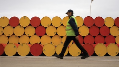 man walking barrels lubricants