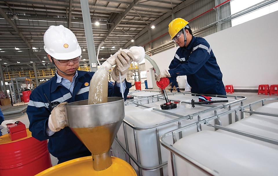 two workers busy in work concentrating over lubricants transferring