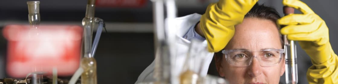lady in safety goggles conducting a lab experiment