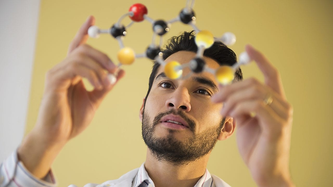Young man examining molecular model