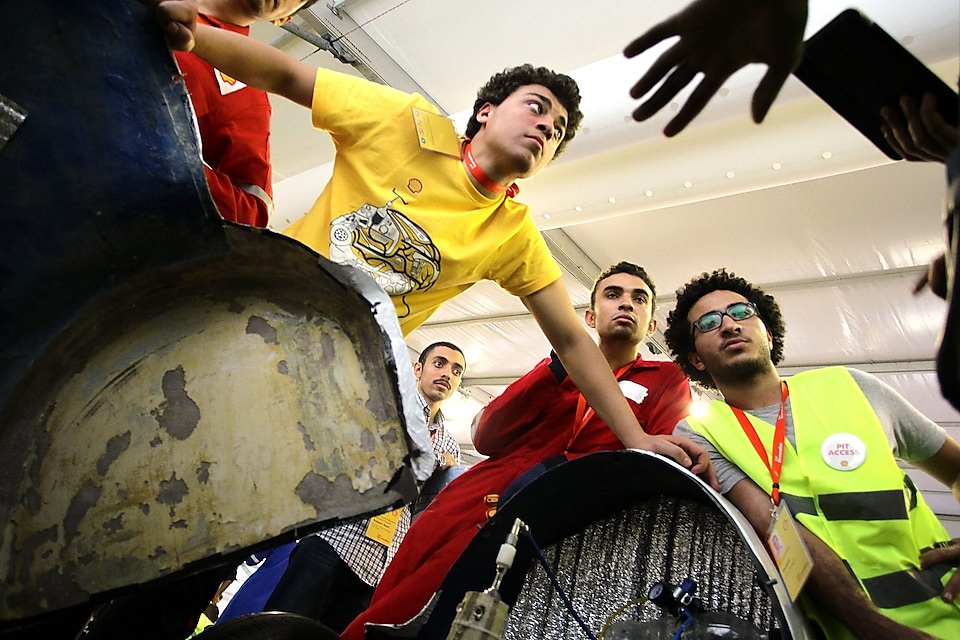 Team members huddle over the Anubis, #512, UrbanConcept, competing for team CUT Eco-Racing UC from Cairo University Faculty of Engineering , Egypt during day two of the Shell Eco-marathon in Manila, Philippines, Friday, Feb. 27, 2015.