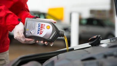 Shell Helix being poured into a car engine