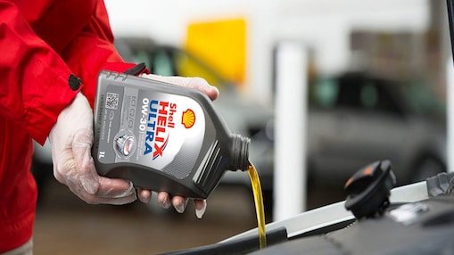 Shell Helix being poured into a car engine