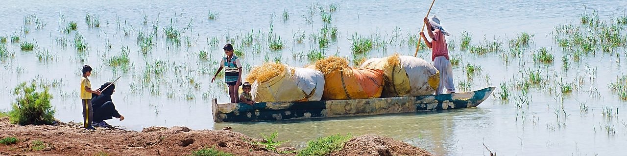 Local people cross the flooded Hawizeh Marshes, near the Majnoon project in Iraq