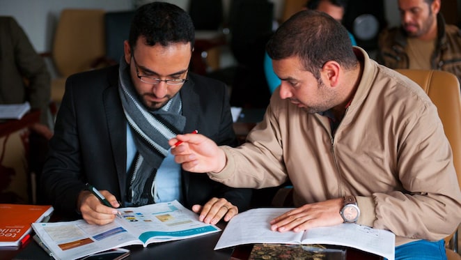 two arabic men solving a problem