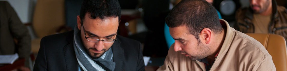 two arabic men solving a problem