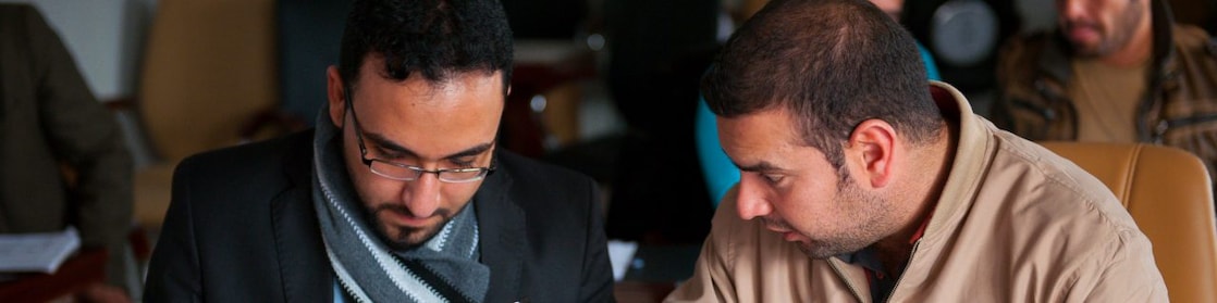 two arabic men solving a problem